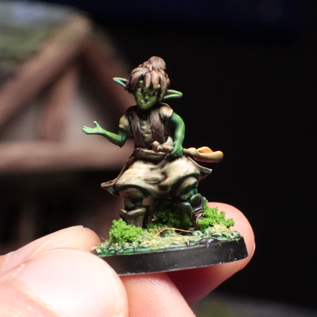 The real Hazel miniature painted green and cream, held on a scenic base in front of the handmade cottage