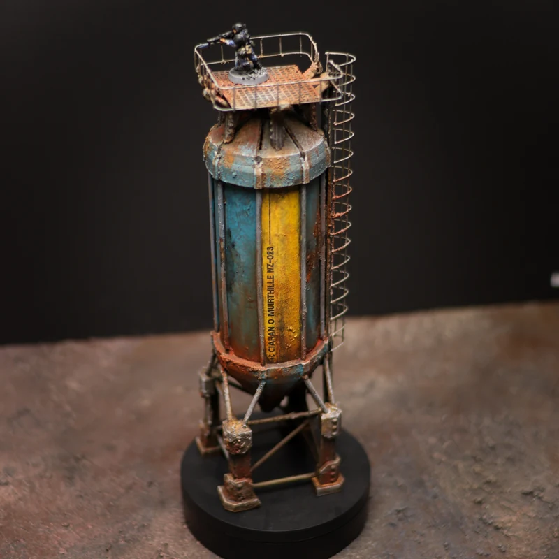 A finished blue and yellow silo with rust weathering, ladder and handmade platform