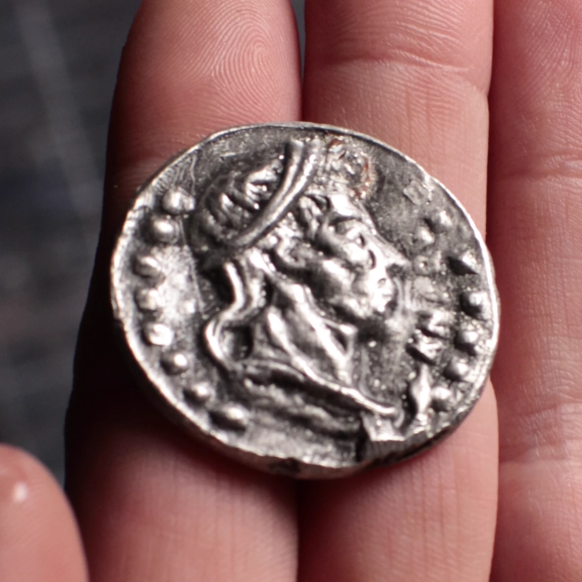 The portrait face of the real cast coin resting in a palm