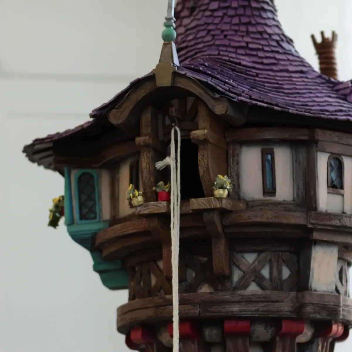 The real painted Rapunzel tower showing its purple roof, teal bay window and lower decorative brackets