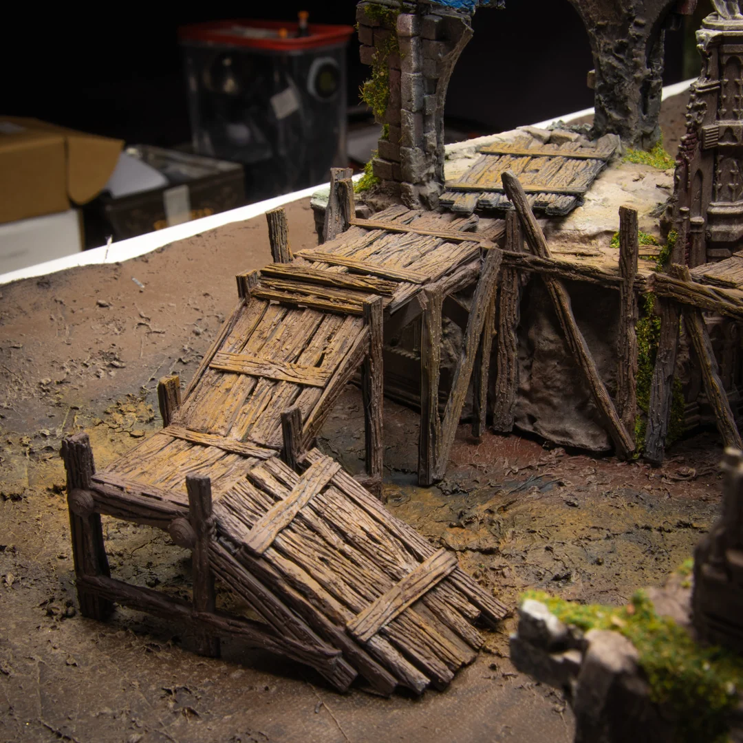 Painted timber scaffolding with ramps, platforms and ladders among miniature ruins